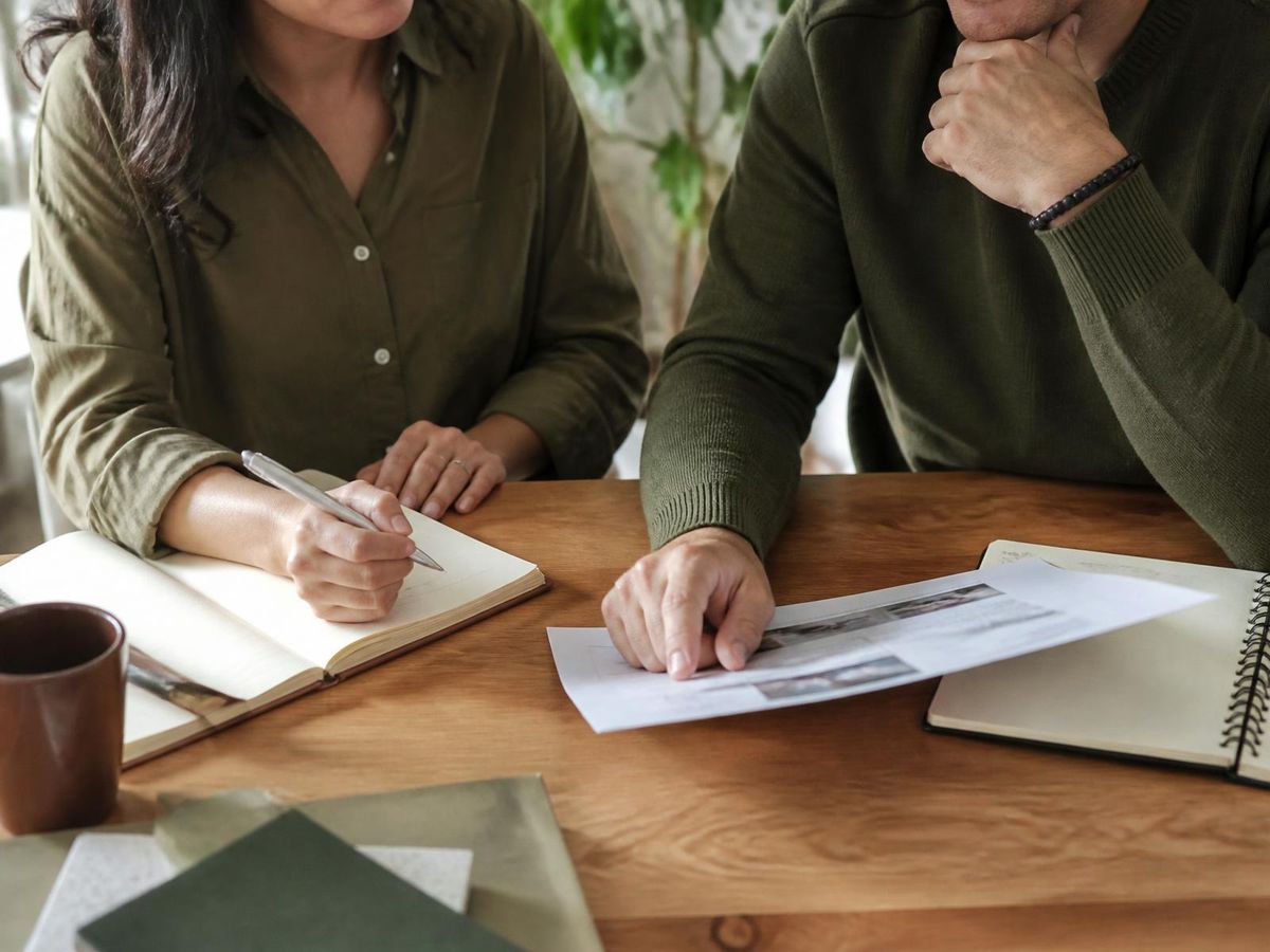Deux professionnels travaillant ensemble autour d’un document imprimé et d’un carnet de notes